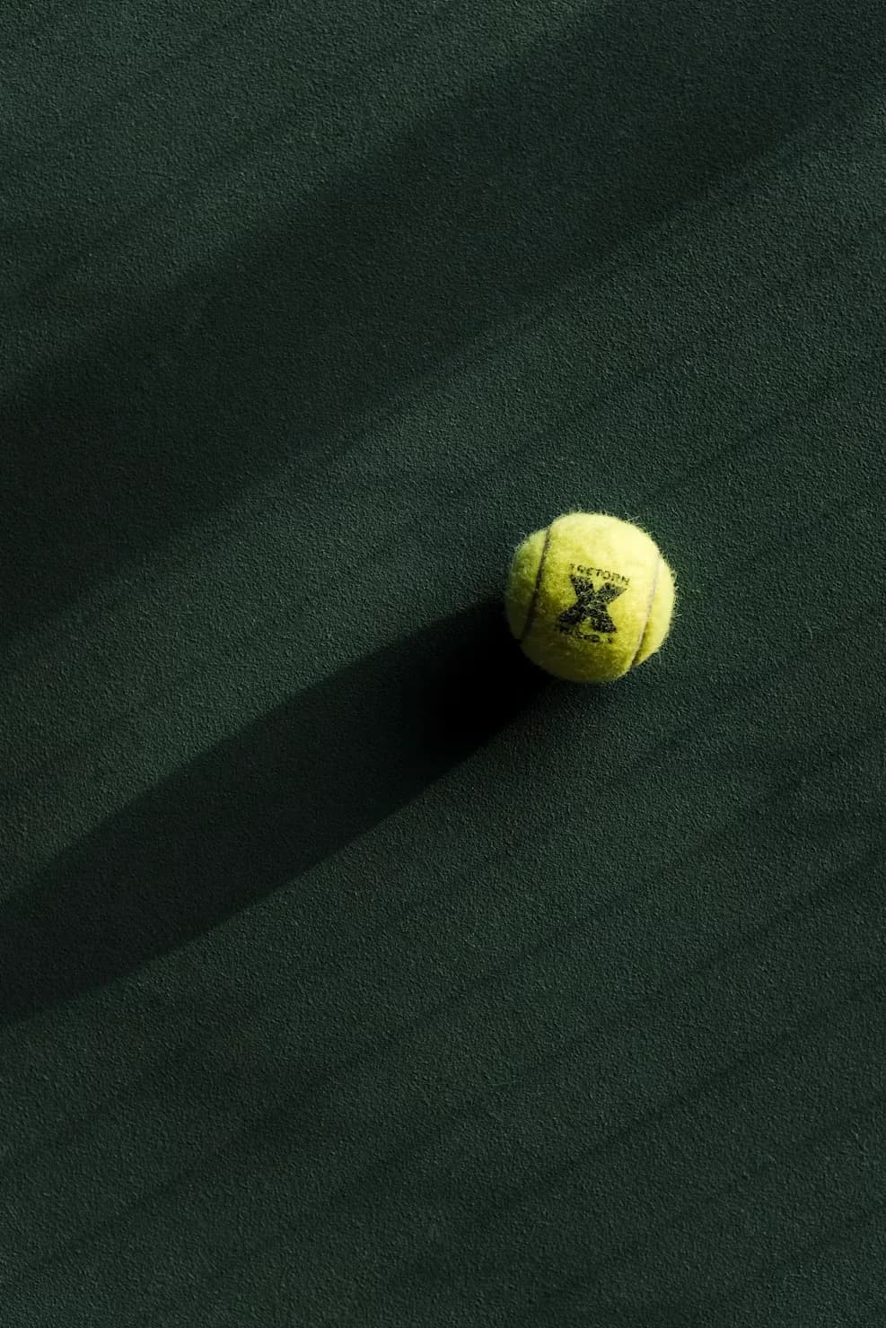 Padel ball on a dark green court
